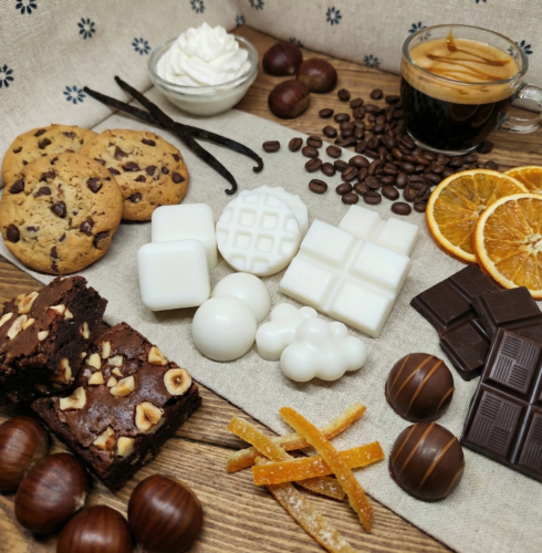 Bodegón de wax melts de cera de soja natural blanca con formas variadas de mini gofres, nubes, esferas y tabletas de chocolate para quemador.