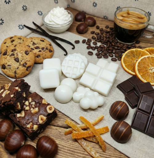 Bodegón de wax melts de cera de soja natural blanca con formas variadas de mini gofres, nubes, esferas y tabletas de chocolate para quemador.