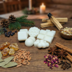 Composición de estilo rústico con tabletas de wax melts de cera de soja blanca. La imagen incluye piñas de pino, ramas de canela atadas y madera natural, representando aromas cálidos de bosque, palo santo y sándalo para la relajación.